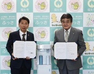 協定書を持つ加藤市長と福島取締役